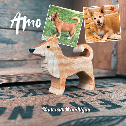 Handgefertigters Holzspielzeug Hund Rüde Amo von Allgäuer Holztiere, hellbraun bemalt mit pflanzlichen Farben, stehend in natürlicher Umgebung, aus bayerischem Ahornholz gefertigt, im Allgäu von Hand hergestellt und für Kinder ab 3 Jahren geeignet.